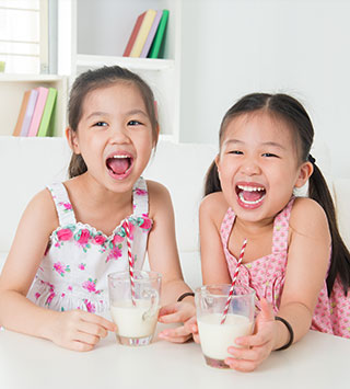 girls drinking milk with stripe paper straws