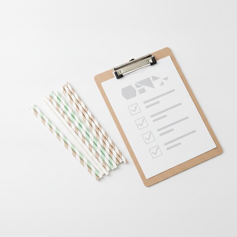 A pile of compostable paper straws next to a BPI Certified logo