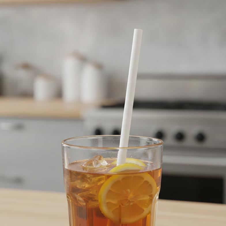 A durable and compostable paper straw sitting in a tall glass of iced coffee, remaining firm and functional