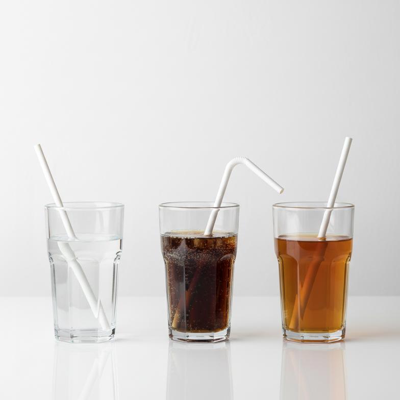 Several paper straw samples being tested in different beverages like iced coffee, soda, and hot tea to compare paper straw samples