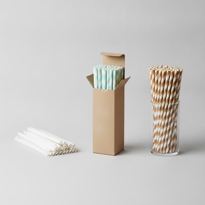 A display showing various paper straw packaging options, from dispenser boxes to individually wrapped straws.