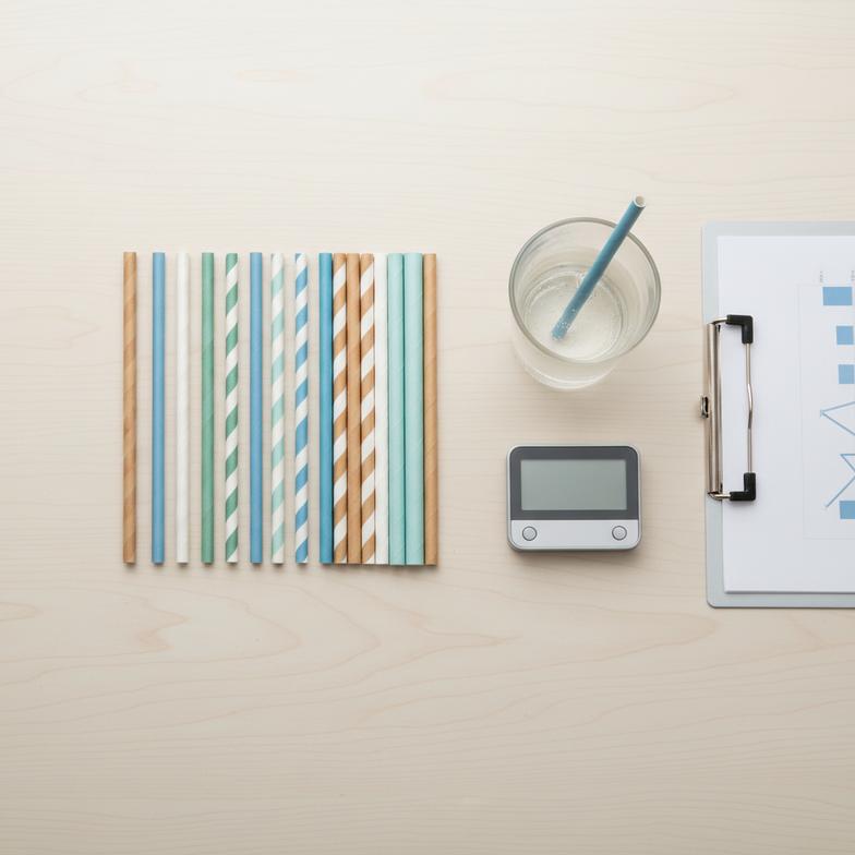 A procurement manager examining different samples of paper straws for their restaurant.