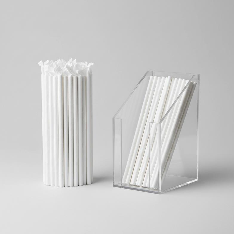 A comparison showing individually wrapped paper straws next to a dispenser of unwrapped paper straws.