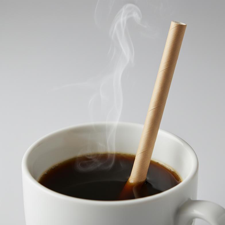 A close-up shot of a paper straw in a steaming cup of coffee, looking sturdy.